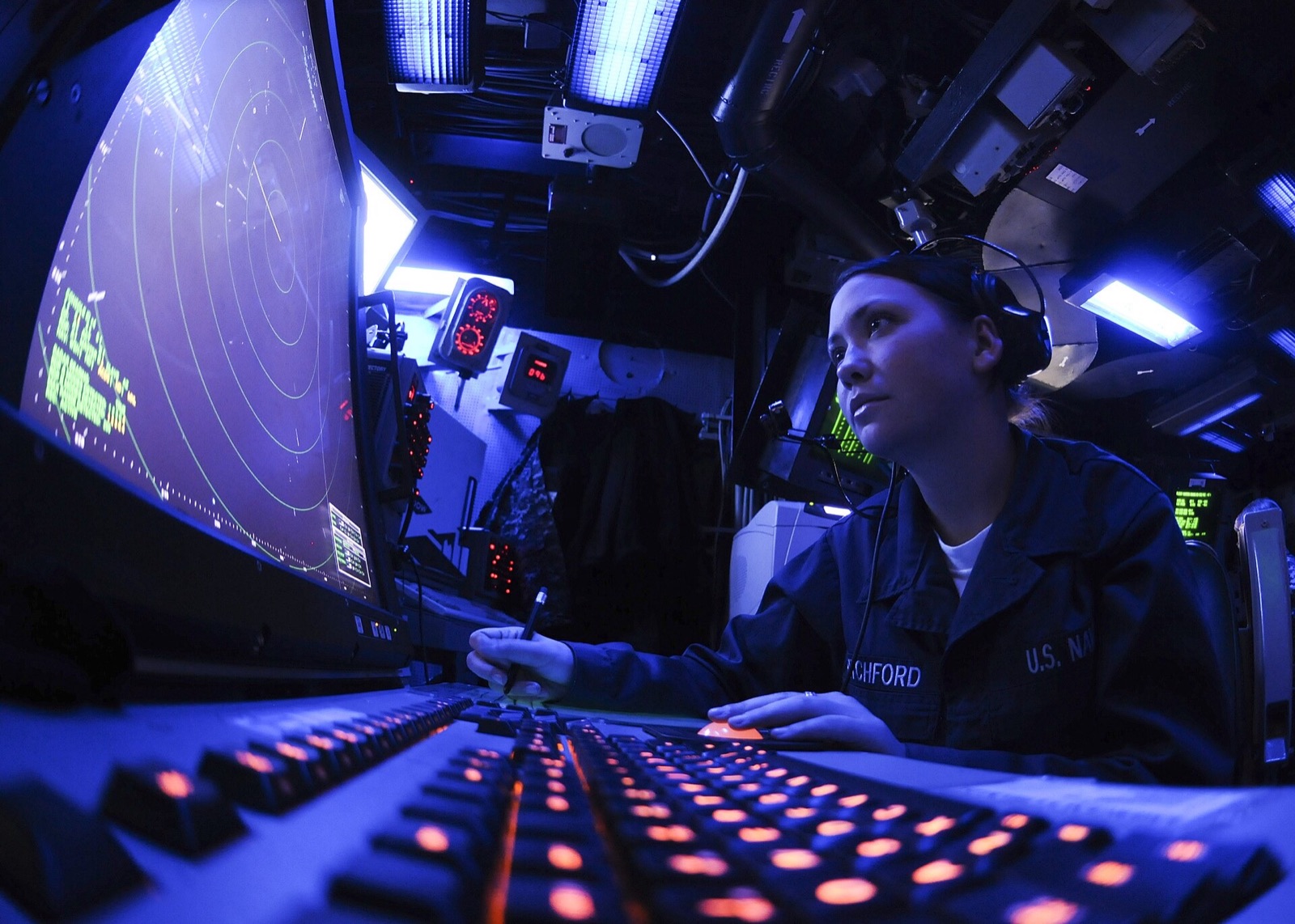 Controllers working at radar screens in a dark operations room
