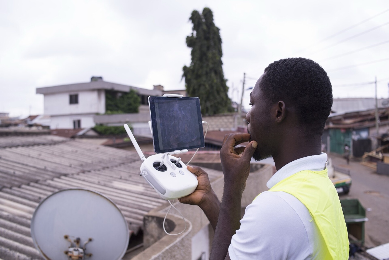 A drone pilot flying a drone with a handheld controller